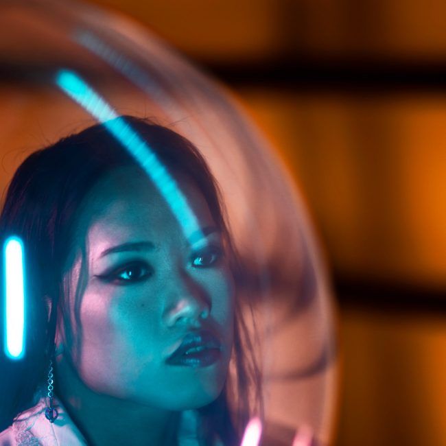 Mujer detrás de un globo iluminada con colores